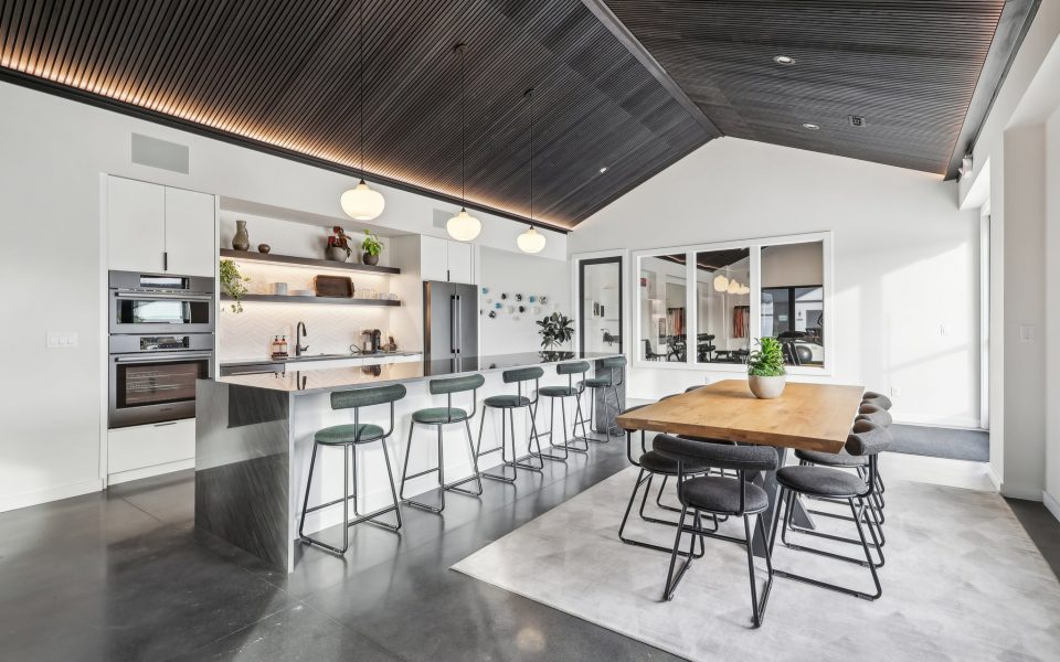 Angled View of the Kitchen Showing the Bar with Barstools and Kitchen Table