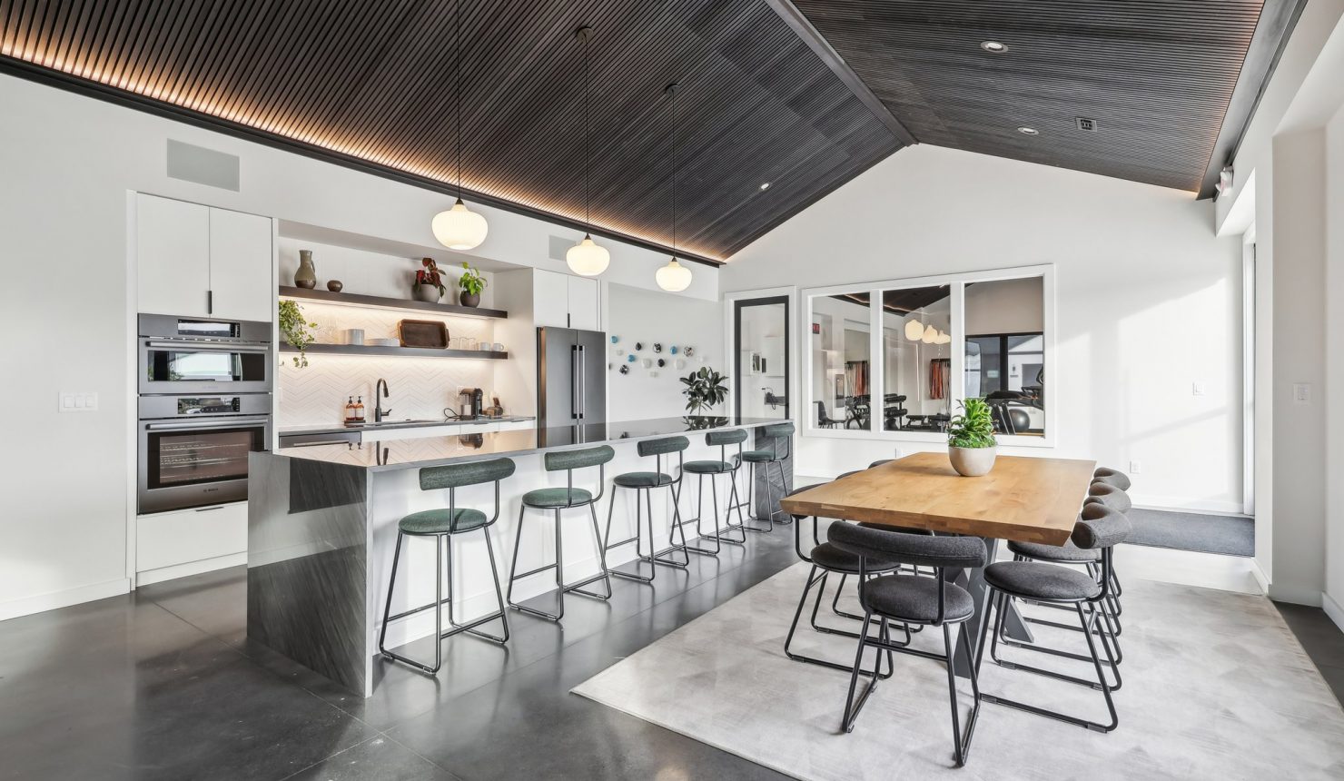 Angled View of the Kitchen Showing the Bar with Barstools and Kitchen Table