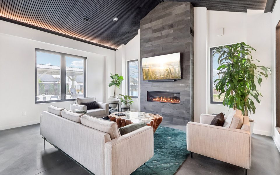 Lounge area in Club House with couch, chairs, fireplace and TV